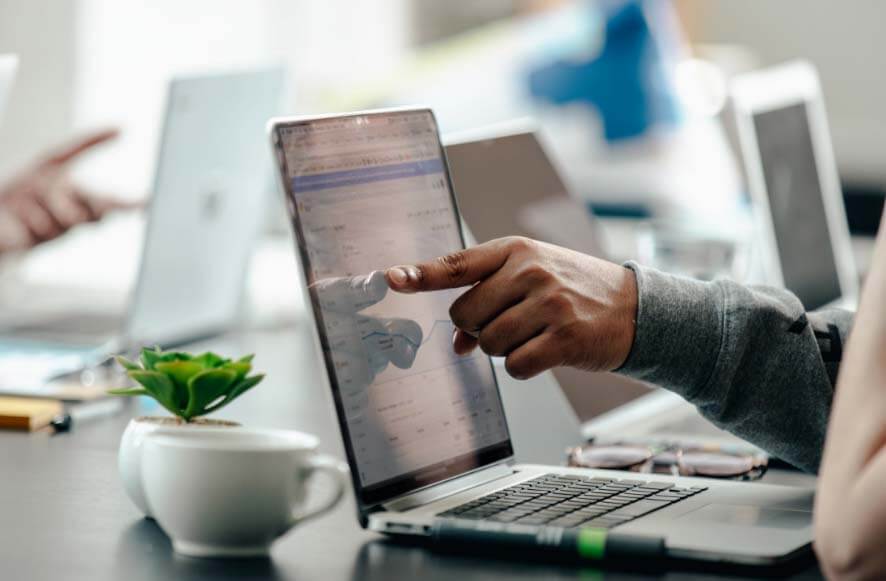 man pointing at laptop screen